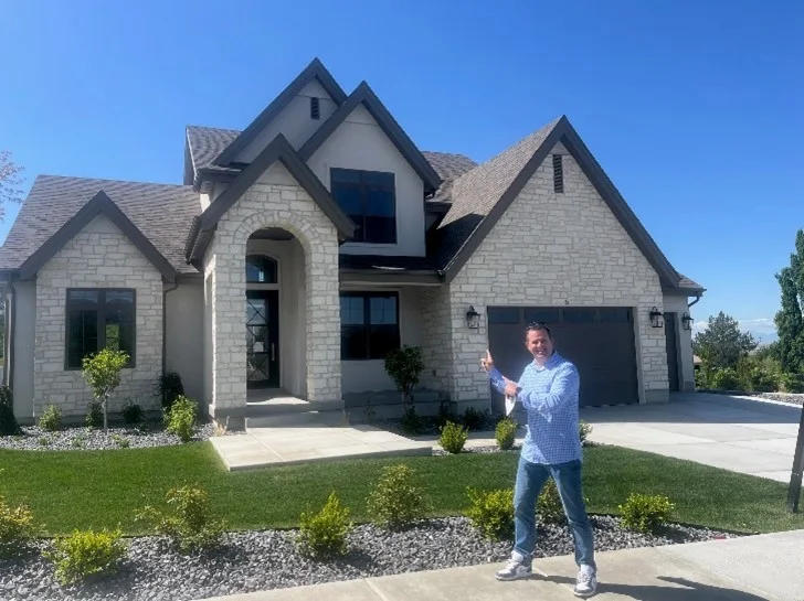 Rich Castleberry, REALTOR, outside a stone-front home he listed